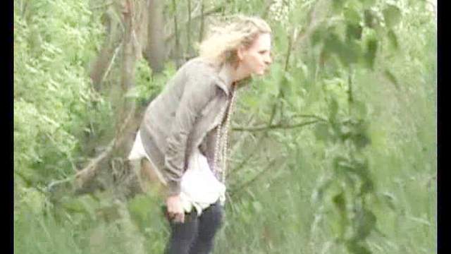 Blond with slender body is pissing outdoors