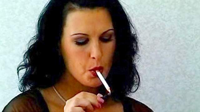 Dark-haired milf is smoking a cigarette