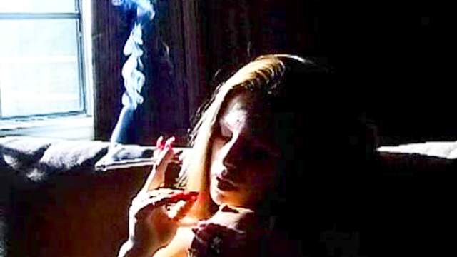 Naked solo girl is smoking while fingering her pussy
