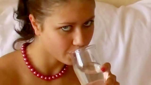 Teen has a drink and poses naked
