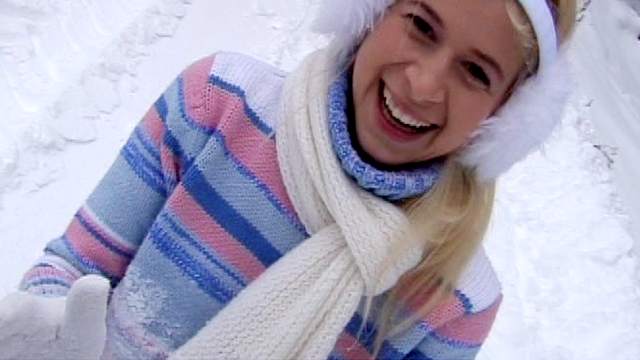 Sweet blonde is undressing outdoors in the snow