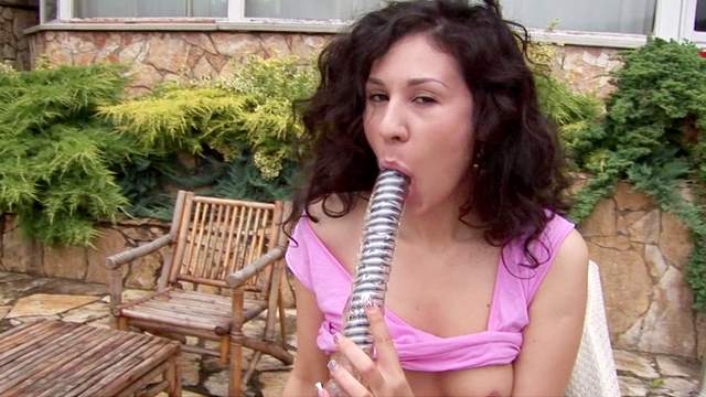 Curly brunette Patricia K is sucking her dildo