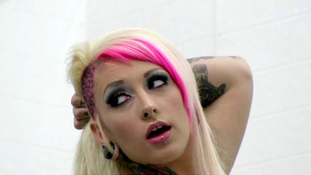 Tattooed blonde is demonstrating her boobies