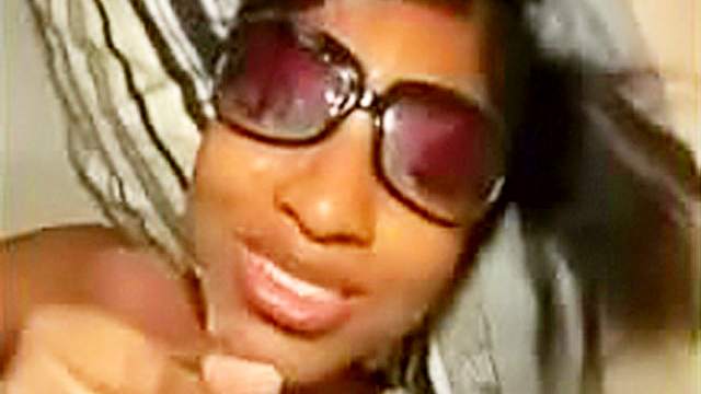 Black babe in sunglasses jacks off a cock