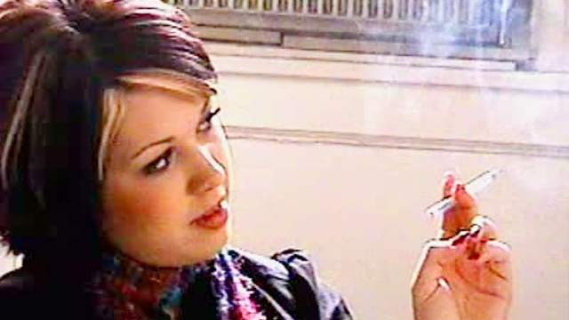 Girl in scarf smokes cigarette