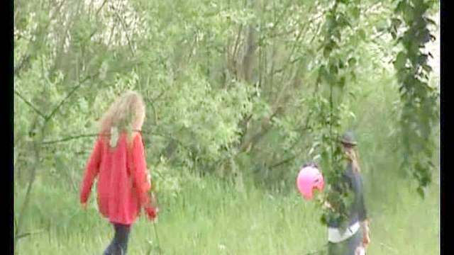 Two girls go pee in a field