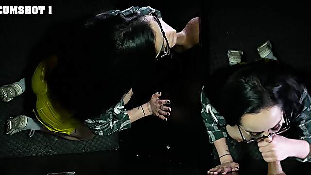 Macey Jade, the hot brunette milf, sucks a black cock through a gloryhole.