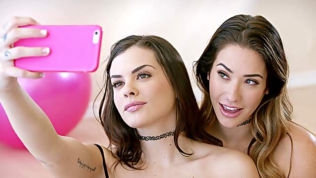 Two young girls share a big cock in an intense threesome scene.