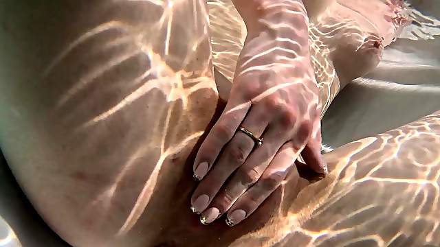 An amateur girl named Mary Moon caresses her peaches on the beach.