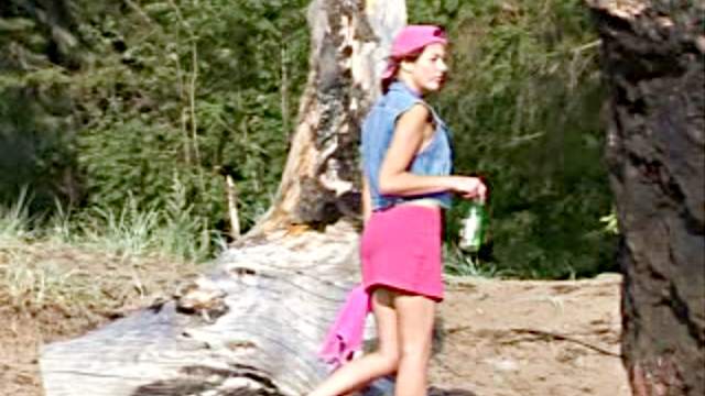 Smoking girl pisses on a log