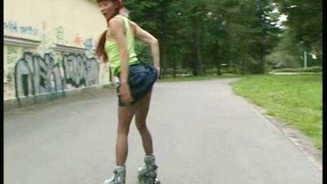 Redhead in rollerblades and pantyhose outdoors