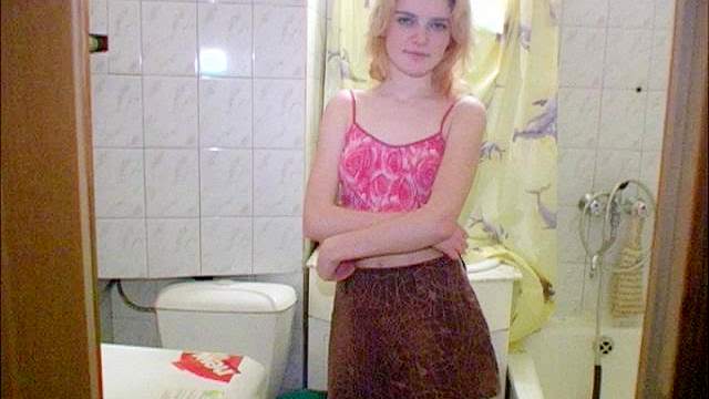 Blonde teen takes a piss in the toilet