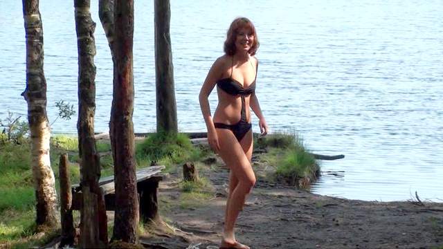 Teen poses by the the lake in a swimsuit