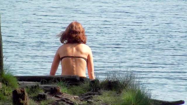 Teen poses by the the lake in a swimsuit