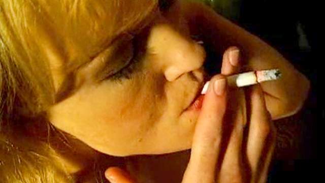 Chick smokes her cigarette in the nude