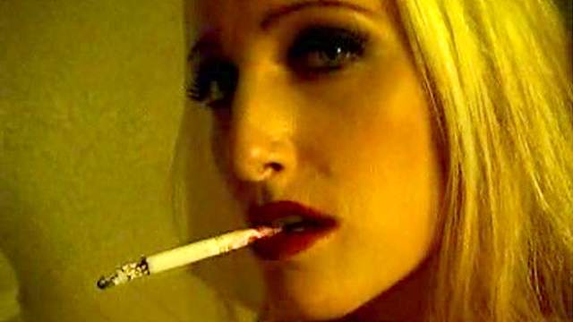 Topless girl in lipstick smokes solo