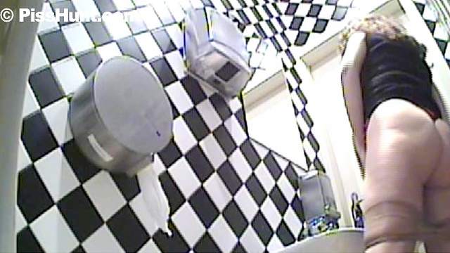 Busty babe is peeing in the public toilet