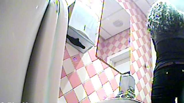 Busty blonde is peeing in the toilet