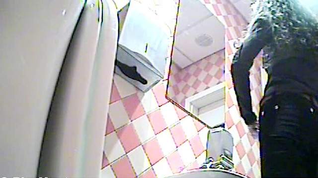 Busty blonde is peeing in the toilet