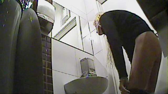 Curly blonde with skinny body is pissing in the toilet