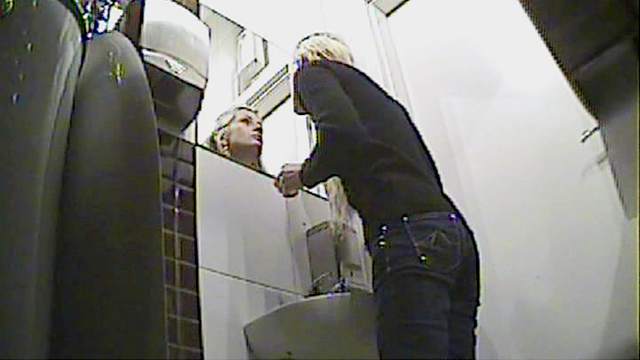 Curly blonde with skinny body is pissing in the toilet