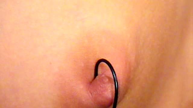 Sweet curly woman is staying with pierced nipples